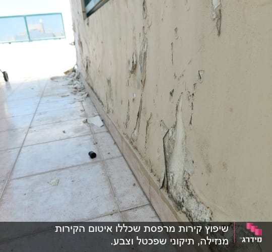 קיר עם צבע מתקלף וכתמים כהים